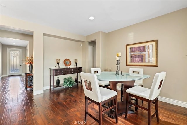 dining room with baseboards, wood finished floors, and recessed lighting