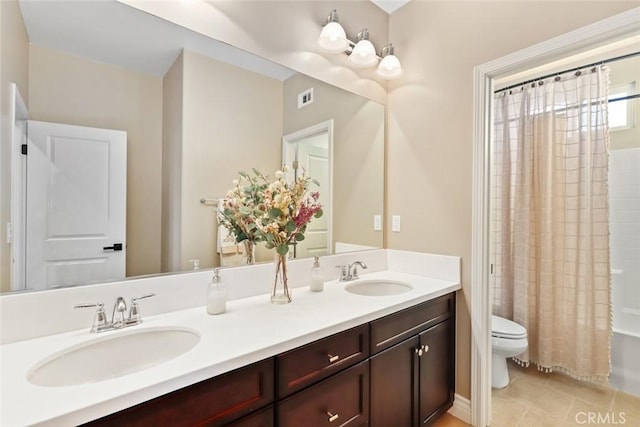 bathroom with visible vents, a sink, toilet, and double vanity