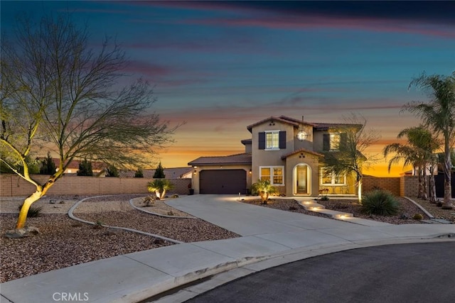 view of front of property featuring fence, driveway, an attached garage, and stucco siding