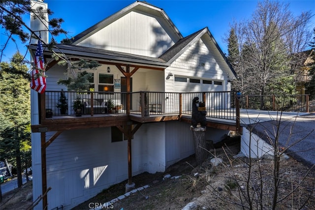 rear view of property with an attached garage and concrete driveway