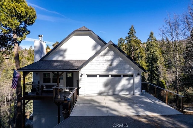 28622 Shenandoah Dr, Lake Arrowhead, CA 92352 - view of front of home featuring a chimney, a garage, a porch, concrete driveway, and a shingled roof