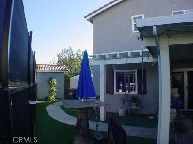 exterior space with a pergola and stucco siding