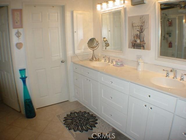 full bath featuring double vanity, a sink, and tile patterned floors