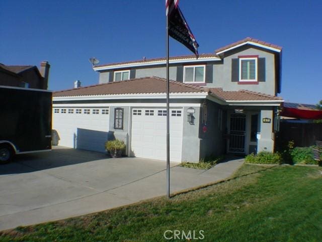 view of front facade with a garage, driveway, a tile roof, and stucco siding