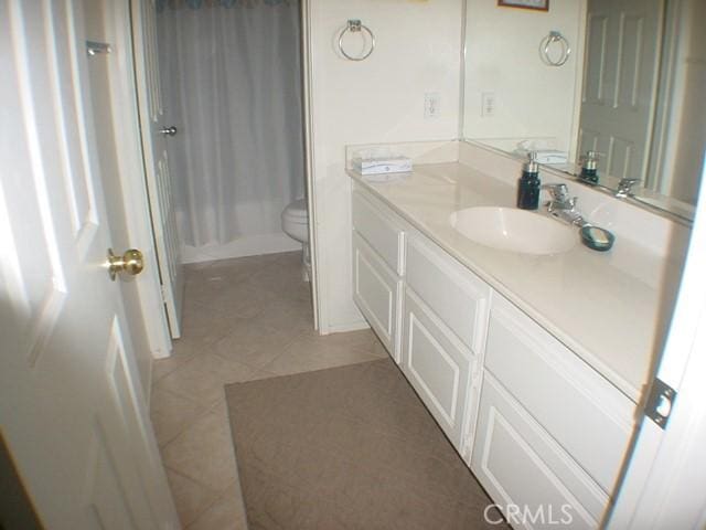 full bath featuring toilet, tile patterned flooring, and vanity