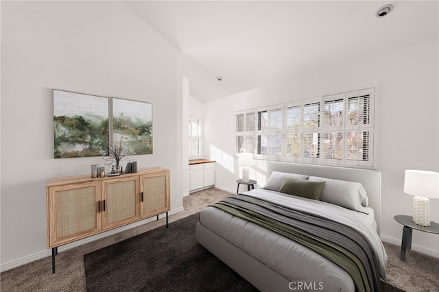 bedroom with vaulted ceiling, carpet, and baseboards