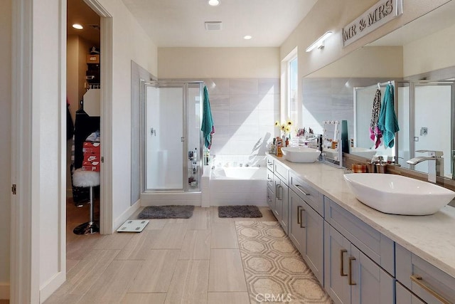 bathroom featuring a sink, a shower stall, and a bath