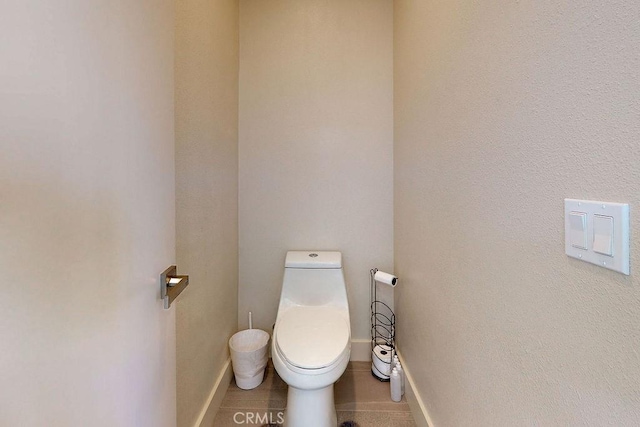 bathroom featuring baseboards and toilet