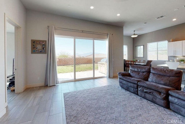 living room with recessed lighting, visible vents, and baseboards