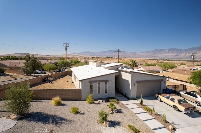 view of front of home featuring driveway, a garage, a mountain view, and stucco siding