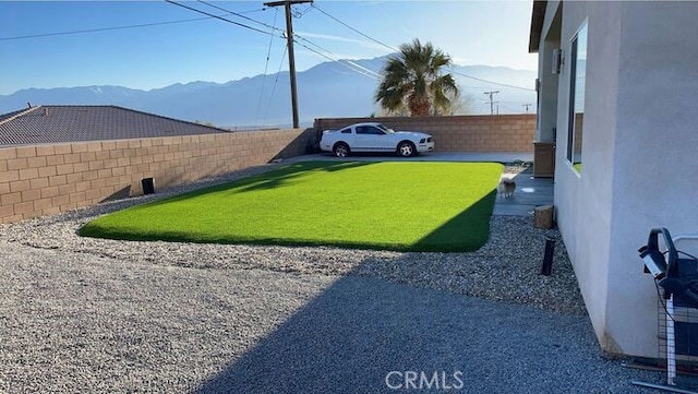 view of yard featuring a fenced backyard and a mountain view