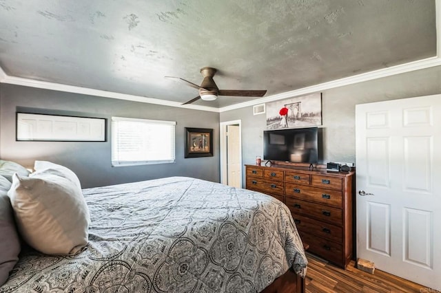 bedroom featuring a ceiling fan, dark wood finished floors, visible vents, and crown molding