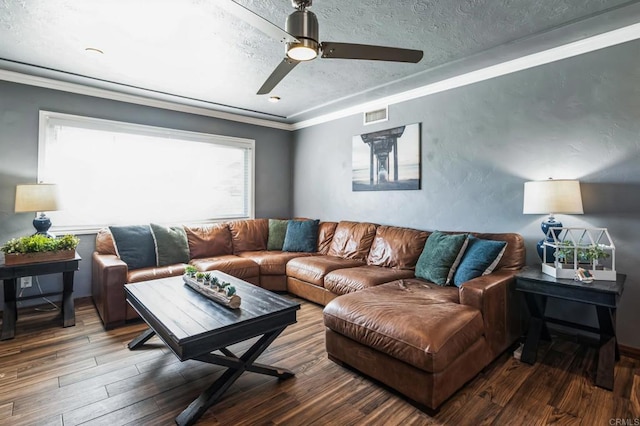 living area with visible vents, crown molding, a textured ceiling, and wood finished floors