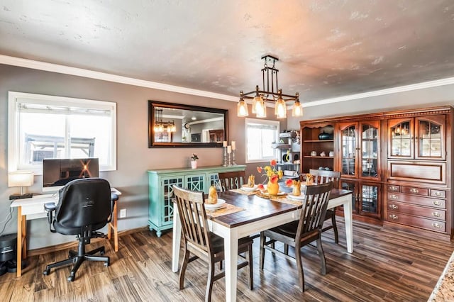 dining space featuring ornamental molding, an inviting chandelier, baseboards, and wood finished floors