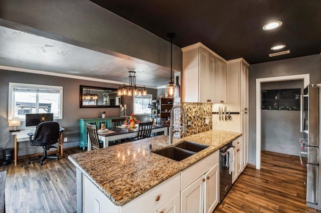 kitchen with white cabinets, light stone countertops, stainless steel appliances, pendant lighting, and a sink