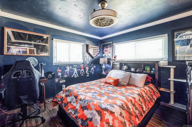 bedroom featuring ornamental molding and wood finished floors