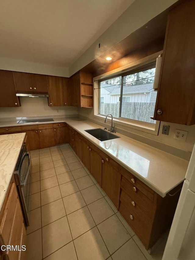 kitchen featuring black electric stovetop, light tile patterned floors, open shelves, light countertops, and a sink