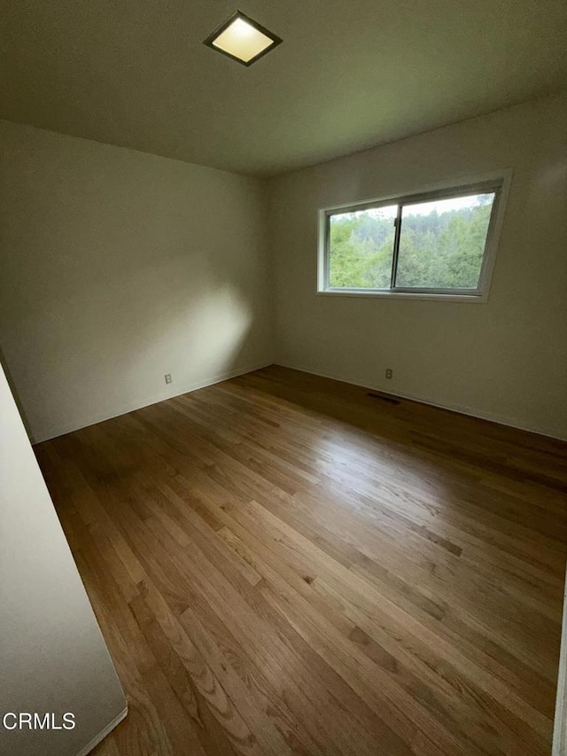 spare room with light wood finished floors and visible vents