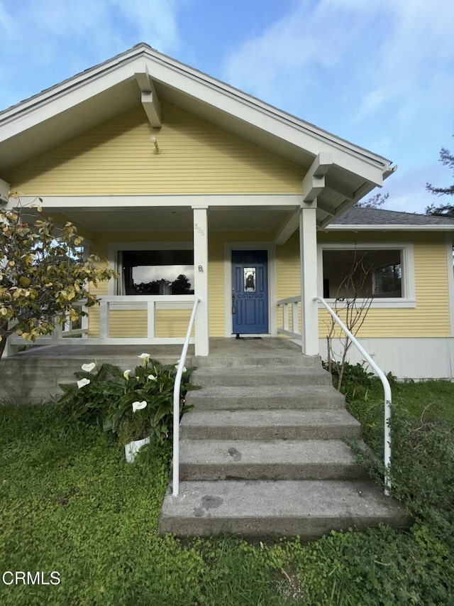 view of exterior entry featuring covered porch