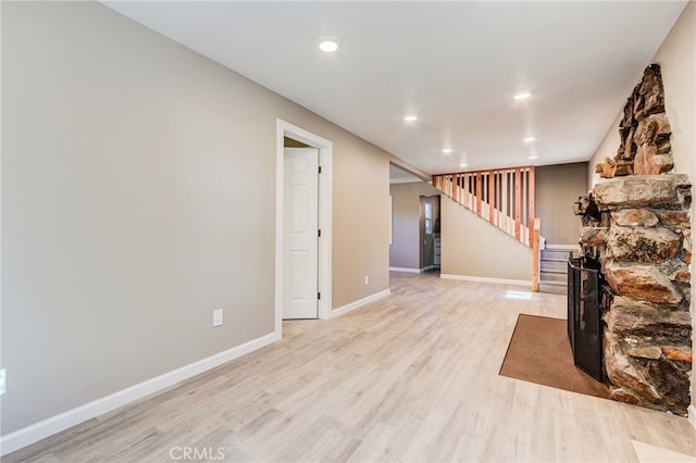 living room with recessed lighting, a fireplace, baseboards, stairway, and light wood finished floors