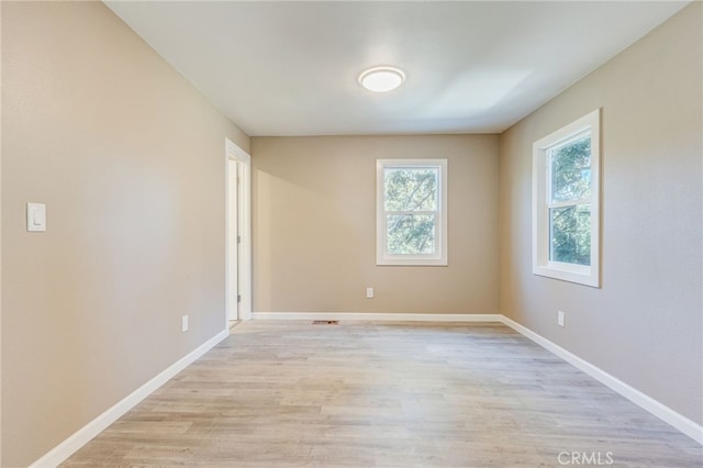 unfurnished room with light wood finished floors and baseboards