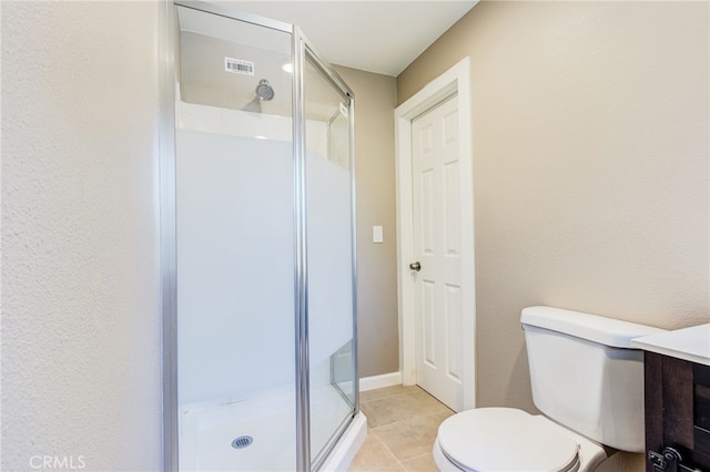 bathroom featuring toilet, visible vents, baseboards, a shower stall, and tile patterned floors