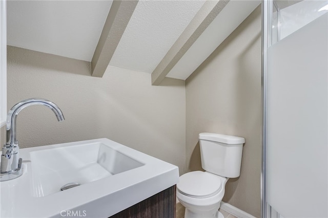 bathroom with lofted ceiling with beams, vanity, and toilet