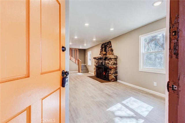 living room with light wood-type flooring, a fireplace, baseboards, and recessed lighting