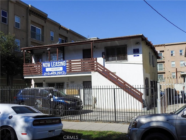 view of property with fence and stairway