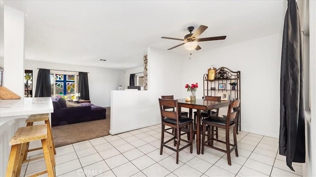 dining space with light tile patterned floors, a ceiling fan, and light colored carpet