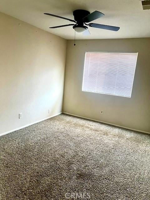 unfurnished room featuring carpet flooring, a ceiling fan, and baseboards