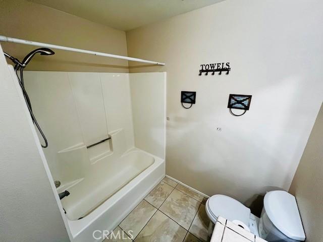 bathroom with toilet and tile patterned floors