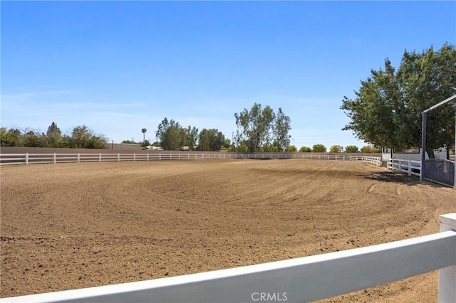 view of yard featuring fence, an enclosed area, and a rural view