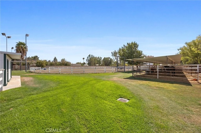 view of yard with a rural view, an outbuilding, and an exterior structure