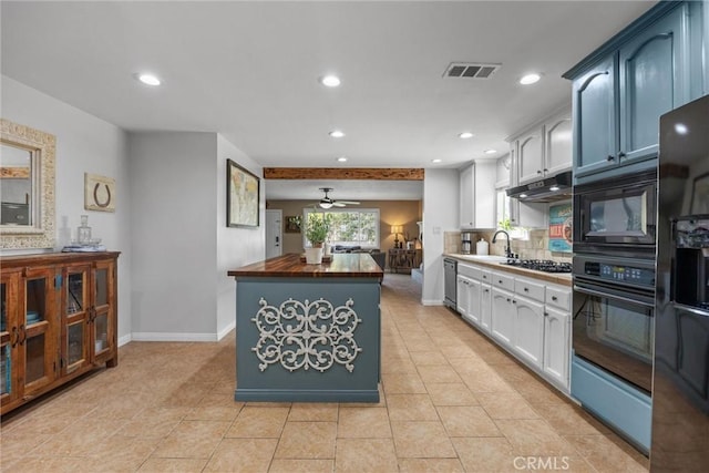 kitchen featuring black appliances, wood counters, visible vents, and white cabinets