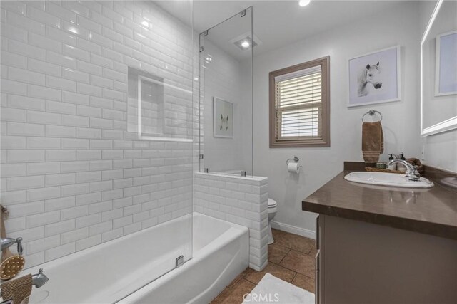 bathroom featuring tile patterned flooring, toilet, vanity, baseboards, and  shower combination