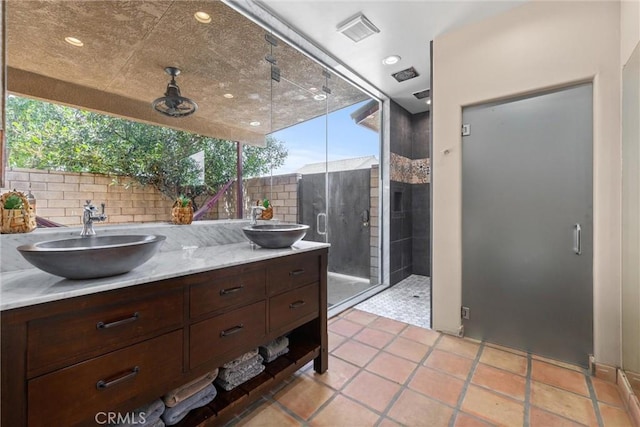 full bathroom with tasteful backsplash, a stall shower, a sink, and visible vents