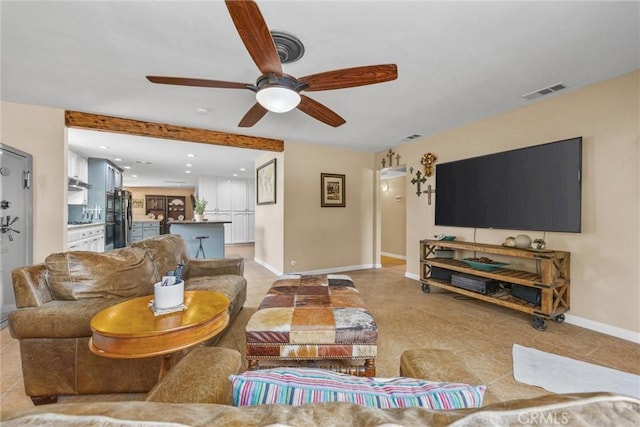 living area featuring light tile patterned floors, a ceiling fan, visible vents, and baseboards