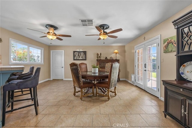 dining area featuring light tile patterned floors, baseboards, visible vents, and french doors