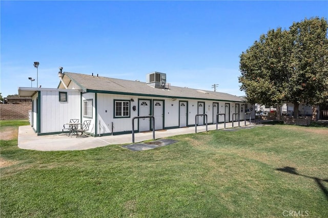 rear view of house featuring a patio, cooling unit, and a yard