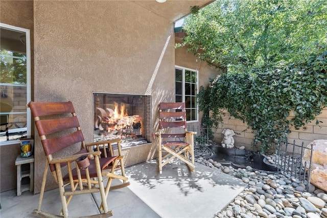 view of patio featuring a lit fireplace