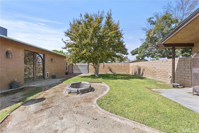 view of yard with a fenced backyard, a patio, and a fire pit