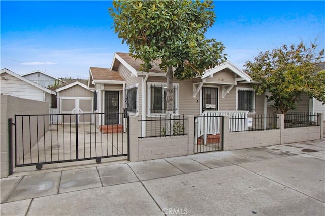 view of front of property with a gate, a fenced front yard, and a shingled roof