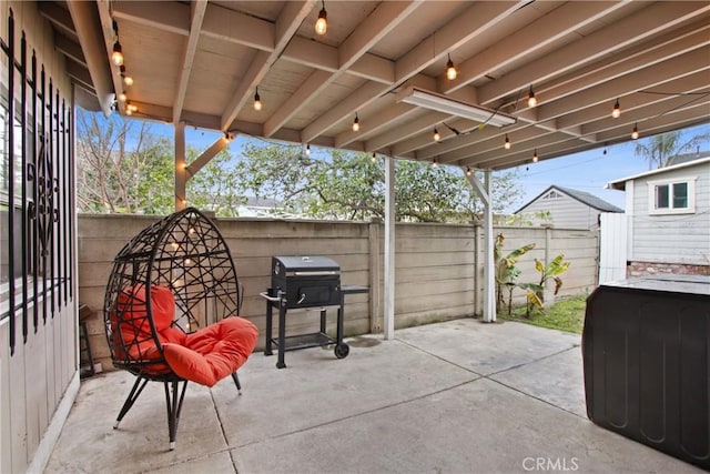 view of patio featuring a grill and fence