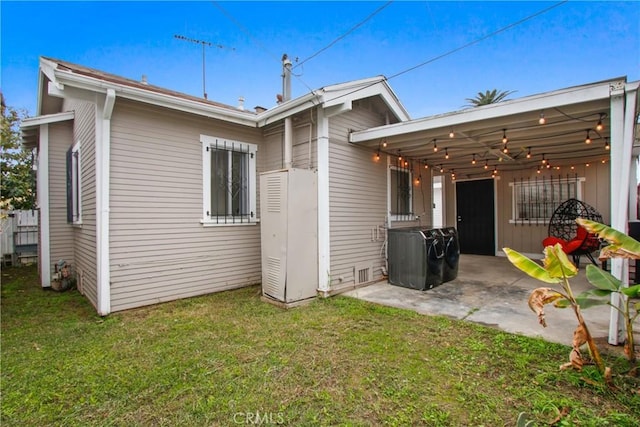 rear view of property featuring a patio and a lawn