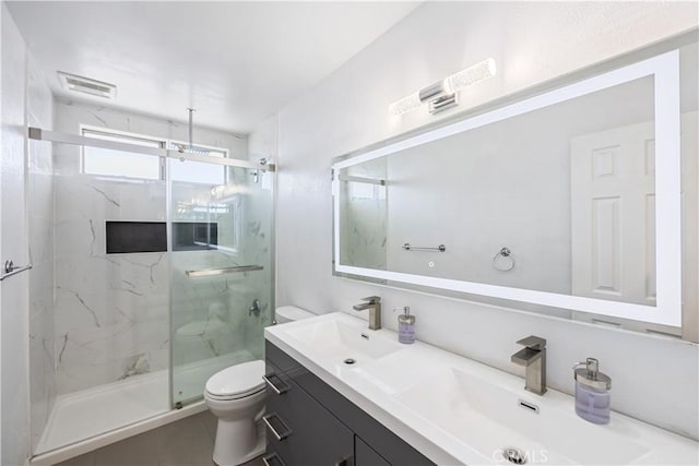 full bathroom featuring toilet, double vanity, a sink, and a marble finish shower