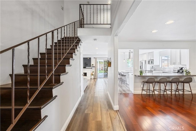 entrance foyer featuring stairway, baseboards, wood finished floors, and recessed lighting