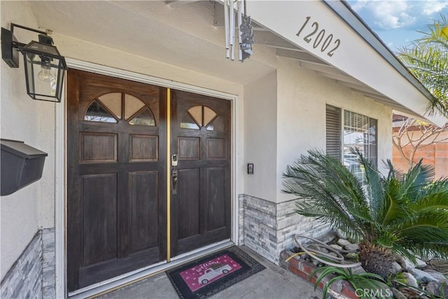 entrance to property featuring stucco siding