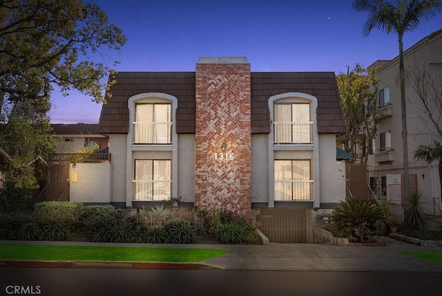 multi unit property with mansard roof and stucco siding