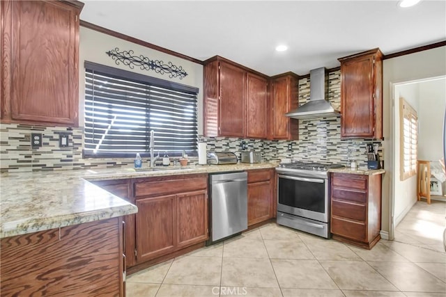 kitchen with crown molding, wall chimney range hood, a wealth of natural light, stainless steel appliances, and a sink